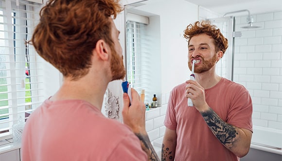 man brushing his teeth for good dental health