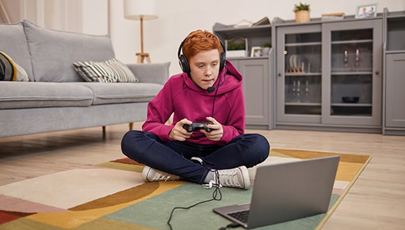 Young boy playing a game on a laptop