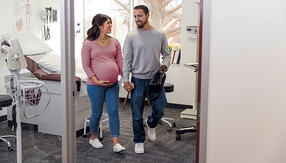 Pregnant woman walking with partner out of the hospital