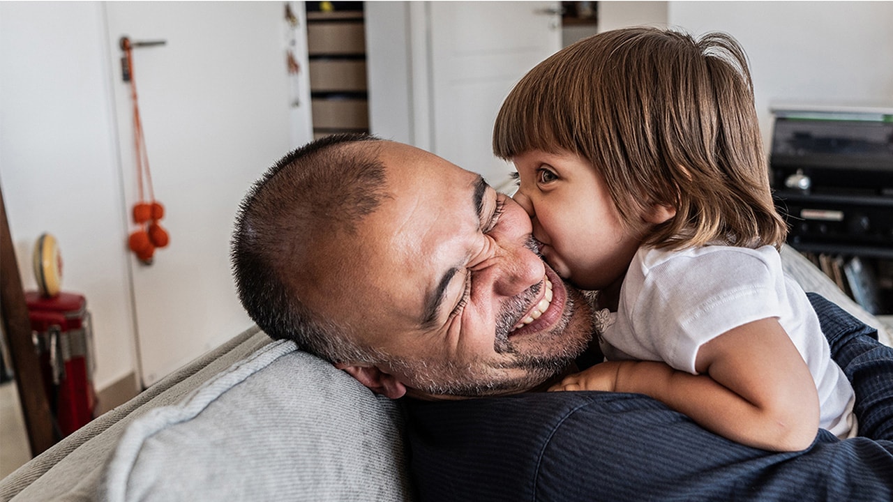 A happy man hugging his child.