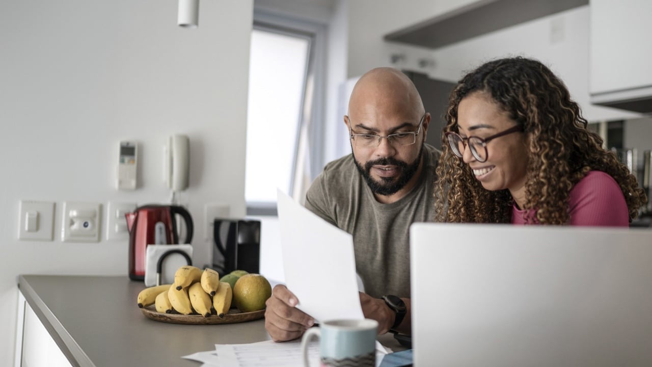 A photo of a man and woman reviewing a piece of paper for suspected fraud activity.