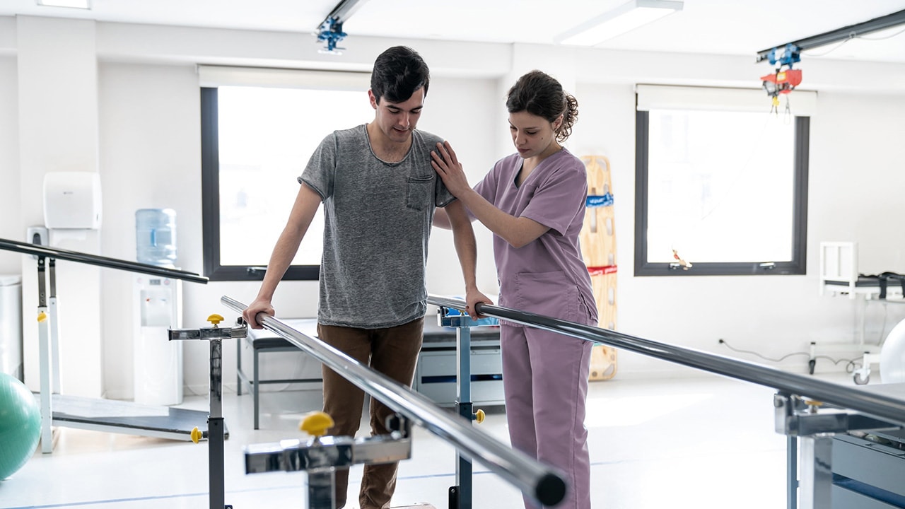 A patient with a nurse doing rehab for an injury.